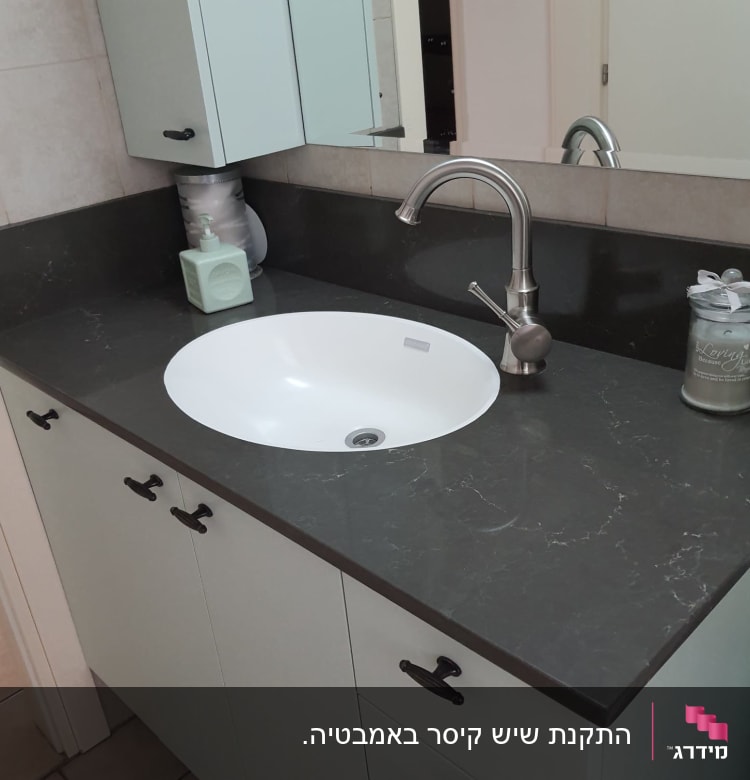 משטח שיש כהה עם כיור עגול וברז מתכת